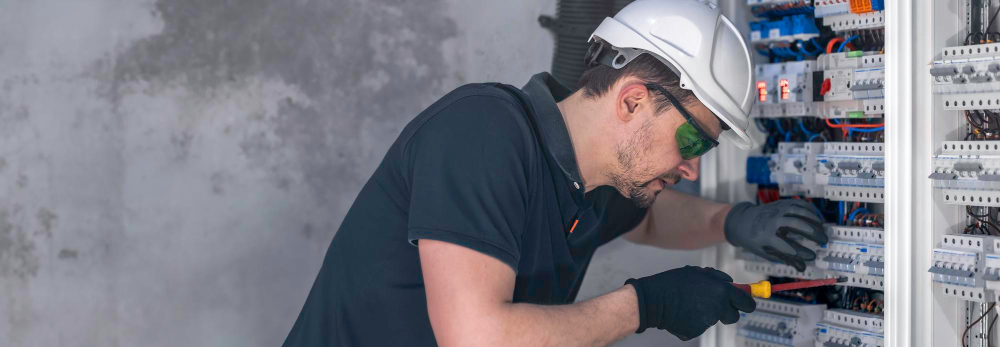 Electrician testing outlet with multimeter in home